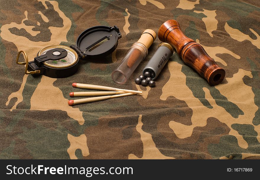Subjects of the hunting ammunition on a camouflage fabric. Subjects of the hunting ammunition on a camouflage fabric.