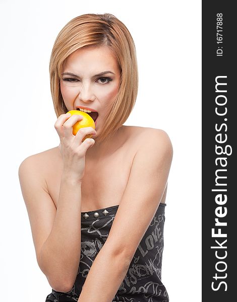 A frontal portrait of a young, blonde woman, biting on a whole lemon, wich she holds in one of her hands. A frontal portrait of a young, blonde woman, biting on a whole lemon, wich she holds in one of her hands.