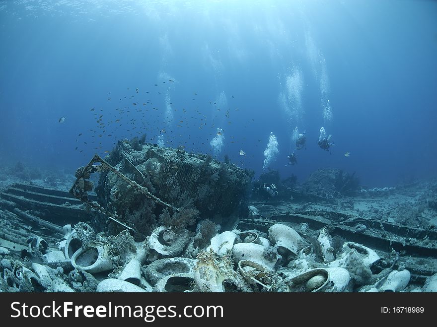 Group of scuba divers exploring a shipwreck.