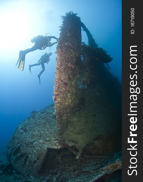 Scuba divers exploring the propellor area of a shipwreck. Dunraven, Beacon rock, Red Sea, Egypt. Scuba divers exploring the propellor area of a shipwreck. Dunraven, Beacon rock, Red Sea, Egypt.