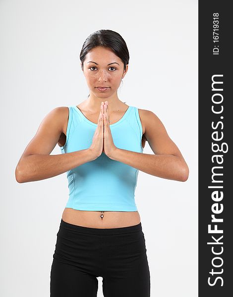 Studio shot of beautiful young woman standing in calm meditating pose during exercise routine. Studio shot of beautiful young woman standing in calm meditating pose during exercise routine