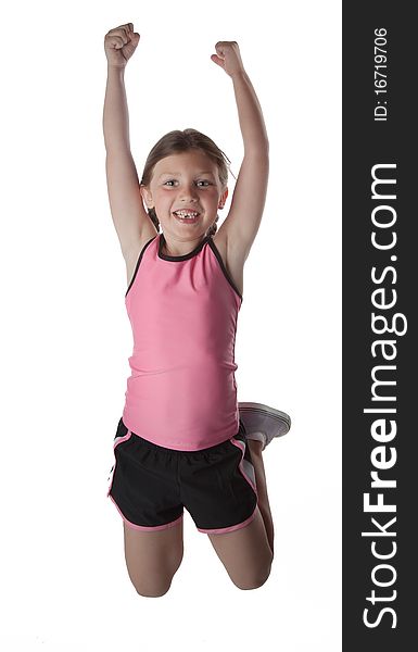 A little girl in athletic sporty clothing jumps in the air. A little girl in athletic sporty clothing jumps in the air