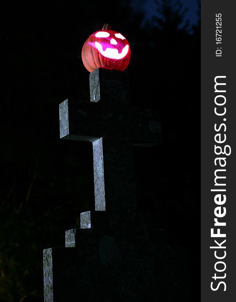 Pumpkin and gravestone at night