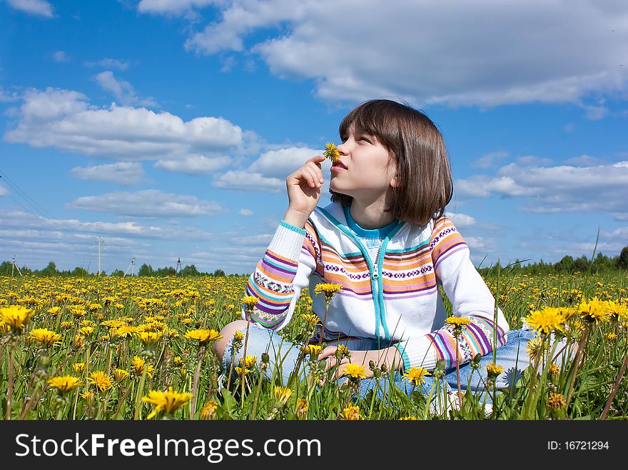 Little girl on the field with yellow daisies