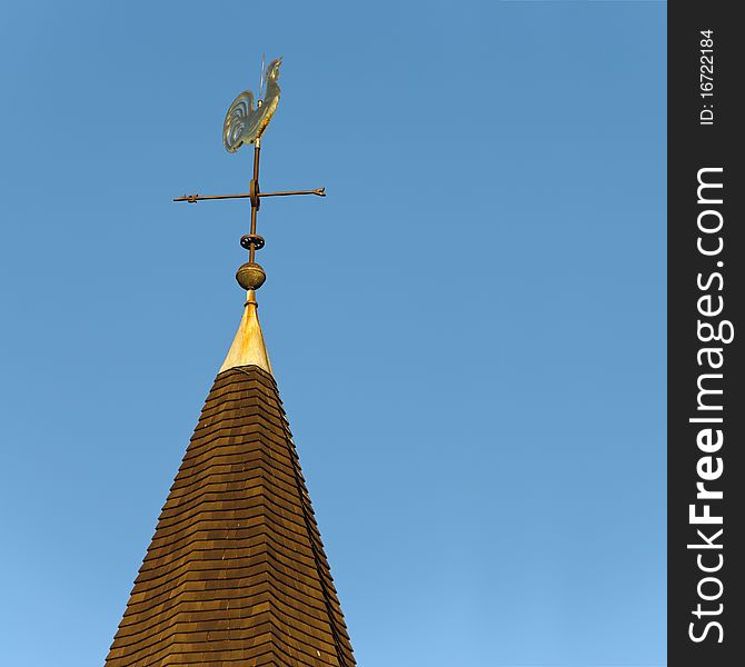 Golden rooster weather vane on church steeple. Golden rooster weather vane on church steeple.