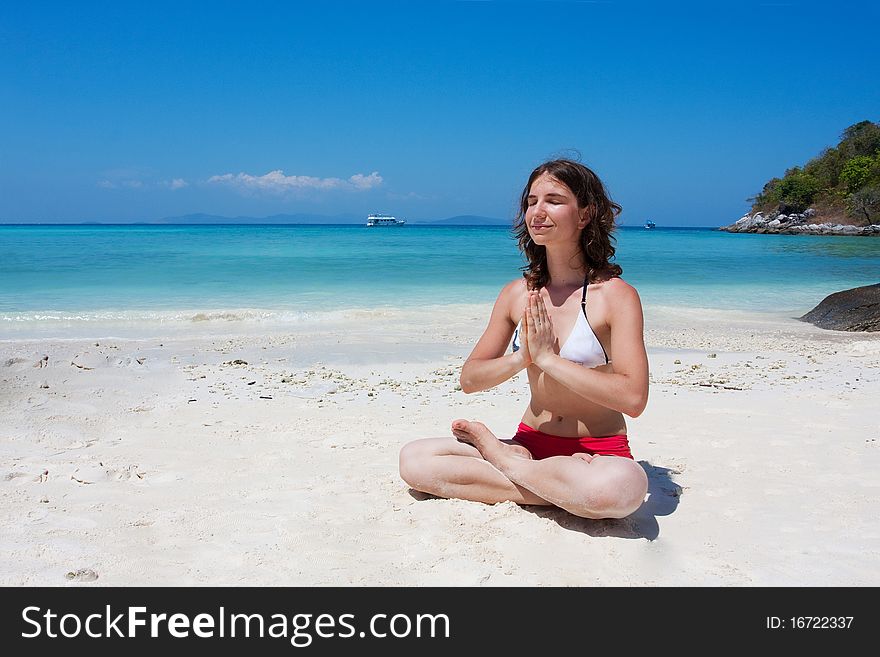 Woman meditating at the beach