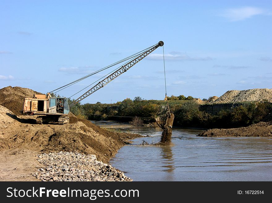 Construction of new seaport. Excavator on the workplace