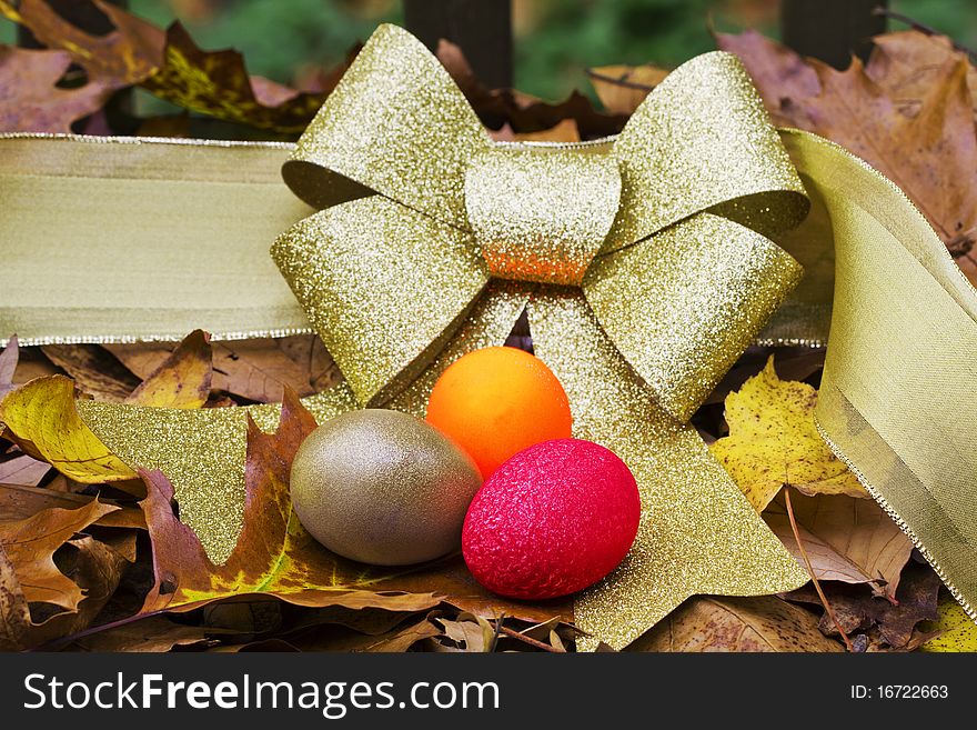 Gold, Red, and Orange Nest Eggs against a gold ribbon in autumn leaves suggest the diversified portfolio needed for retirement in the autumn of a couple's life together. Gold, Red, and Orange Nest Eggs against a gold ribbon in autumn leaves suggest the diversified portfolio needed for retirement in the autumn of a couple's life together.