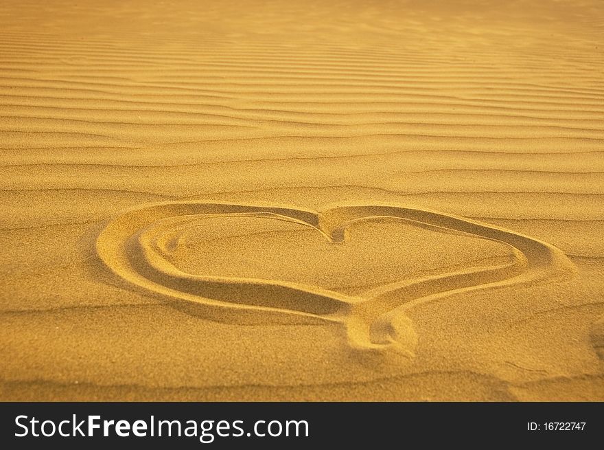 A photography of a heart in the sand. A photography of a heart in the sand