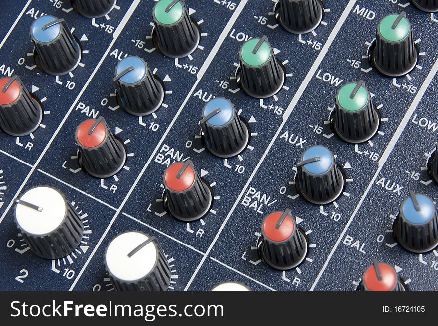Close up image of an analog audio mixing board with several channels Dials and volume levels are visible. Close up image of an analog audio mixing board with several channels Dials and volume levels are visible.