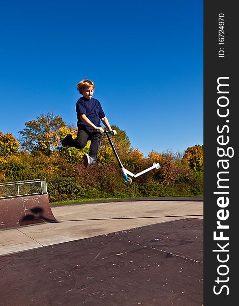 Young boy going airborne with scooter