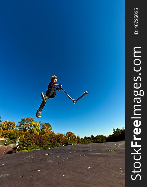 Young boy going airborne with his scooter