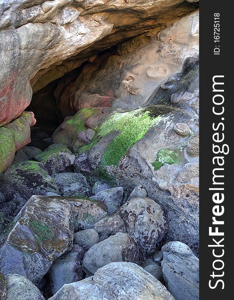 A small dry sea cave. Large rocks with moss. Photograph originally taken on the Oregon coast. A small dry sea cave. Large rocks with moss. Photograph originally taken on the Oregon coast.