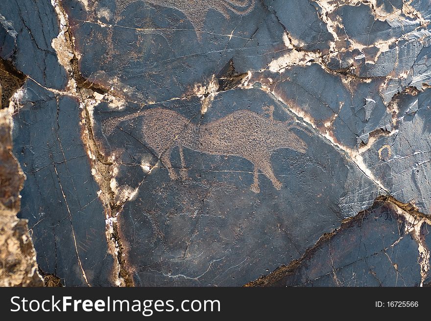Petroglyph carved into rock surface by prehistoric asian nomads. Sarmishsay, Uzbekistan