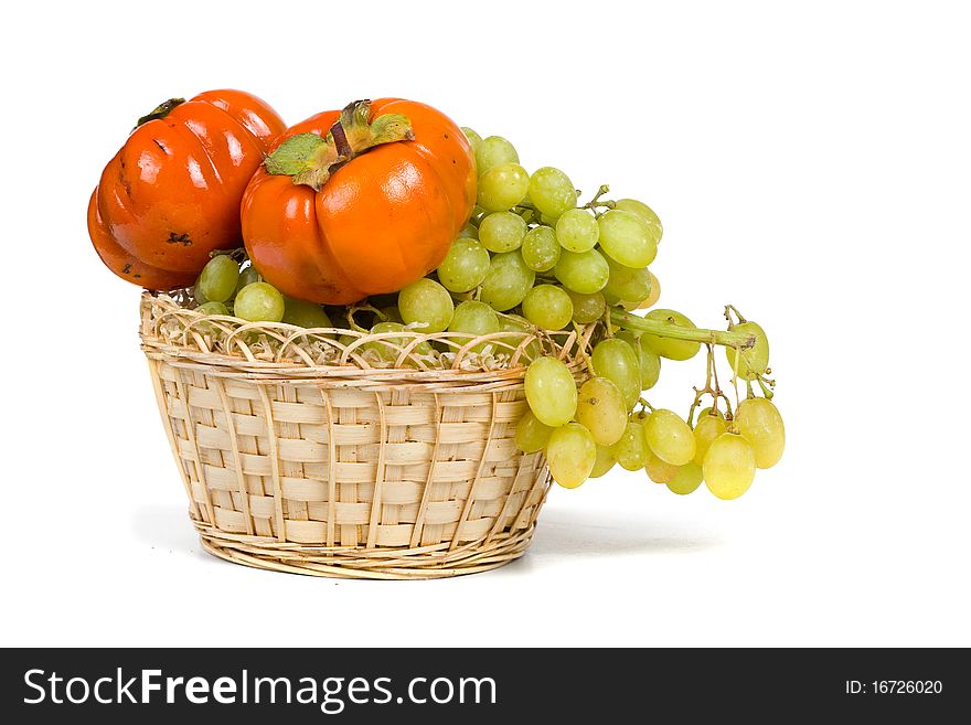 Ripe persimmons and grapes isolated on a white background