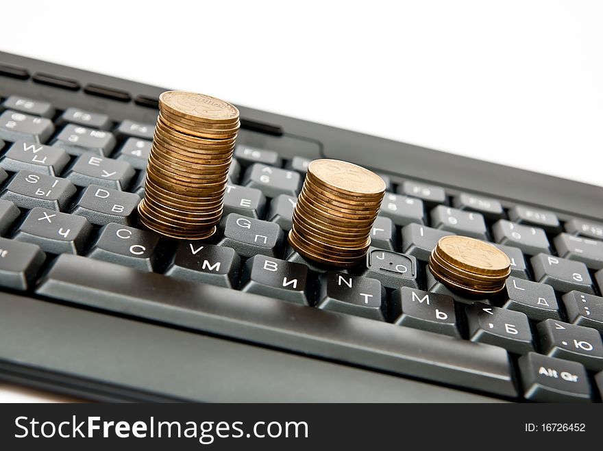 Stacks of coins on a black computer keyboard