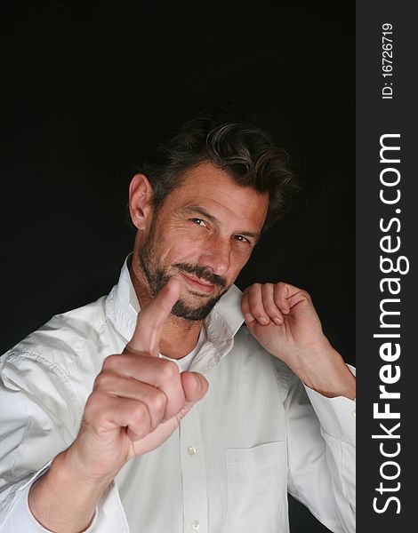 Portrait of man with beard showing with his finger on black background. Portrait of man with beard showing with his finger on black background