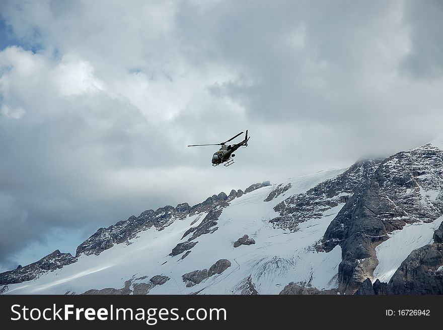 Mountain rescue helicopter above Marmolada slopes. Mountain rescue helicopter above Marmolada slopes.