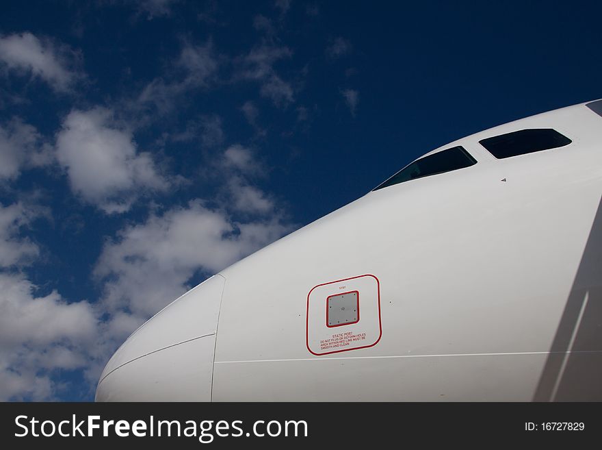 Aeroplane nose in front of blue cloudy sky. Aeroplane nose in front of blue cloudy sky