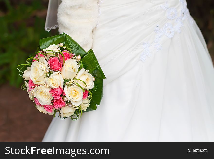 Bride and groom near the fountain with wedding bouquet