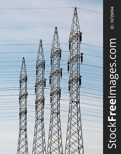 Four high voltage towers against a blue sky. Four high voltage towers against a blue sky