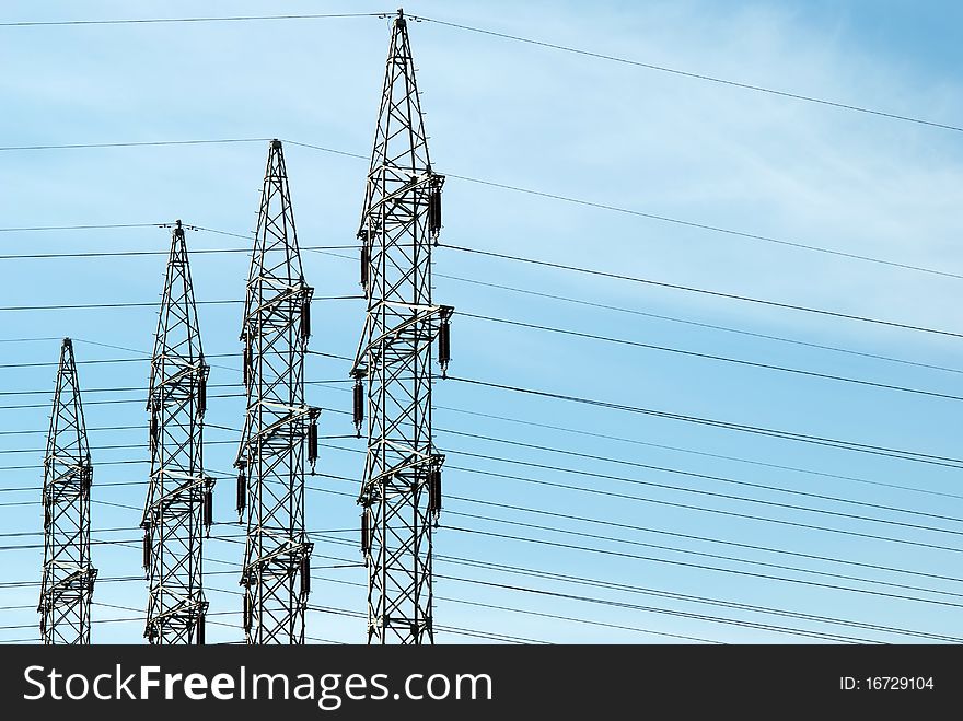 Four high voltage towers against a blue sky. Four high voltage towers against a blue sky
