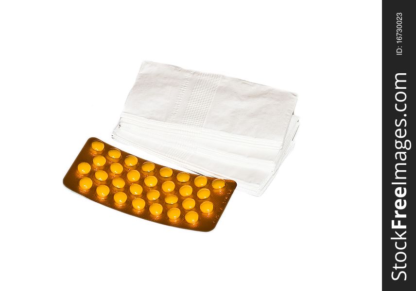 Orange pills in a package and white tissues isolated on white