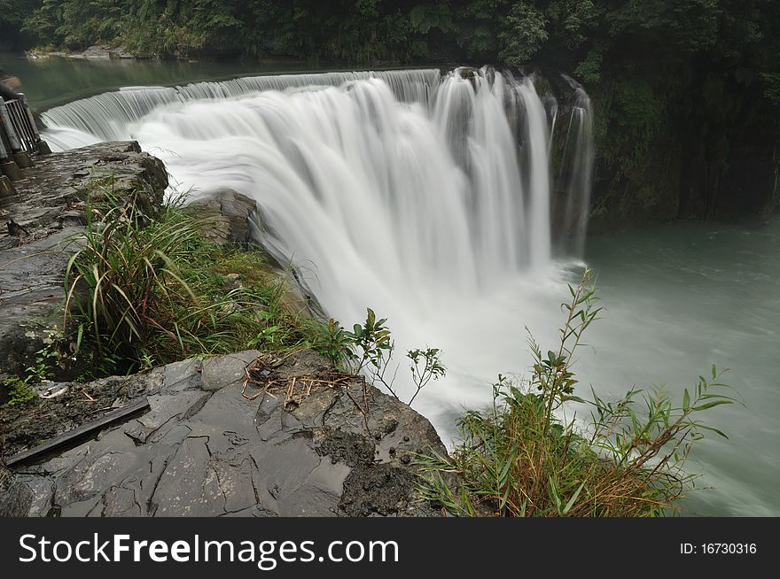 It is a waterfall in the cloudy day