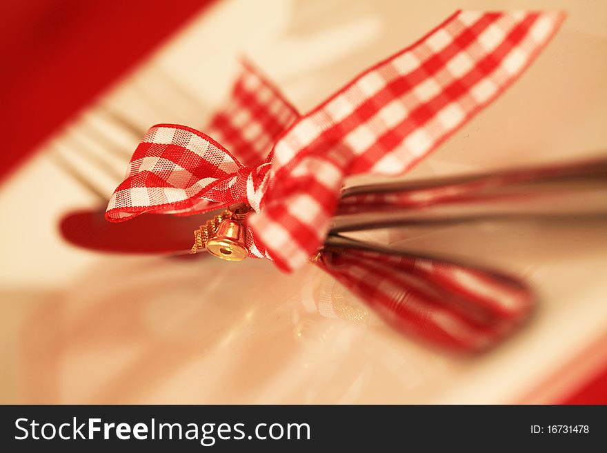 Christmas Cutlery with a bow on a white plate. Christmas Cutlery with a bow on a white plate.