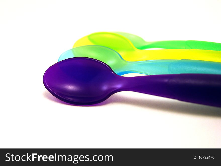 Colored baby spoons isolated on white background