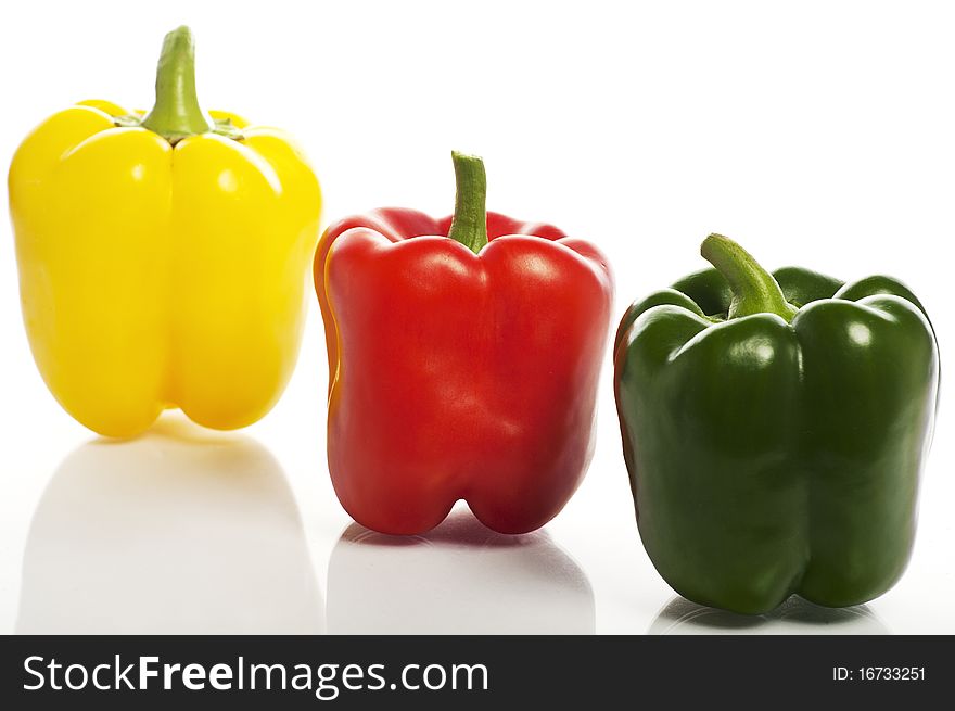 Yellow, red and green peppers standing in raw on the white background. Yellow, red and green peppers standing in raw on the white background