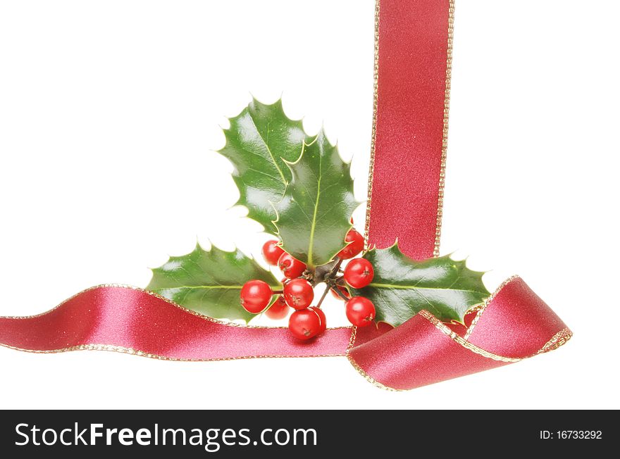 Christmas motif a gold edged red ribbon with holly leaves and ripe red berries. Christmas motif a gold edged red ribbon with holly leaves and ripe red berries