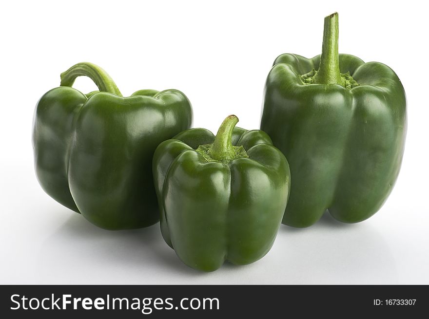 Three green fresh  peppers on the white background