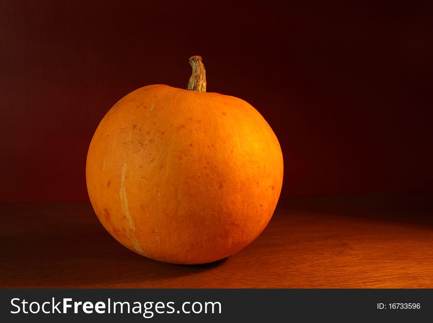 A pumkin on a table with side lighting. A pumkin on a table with side lighting.