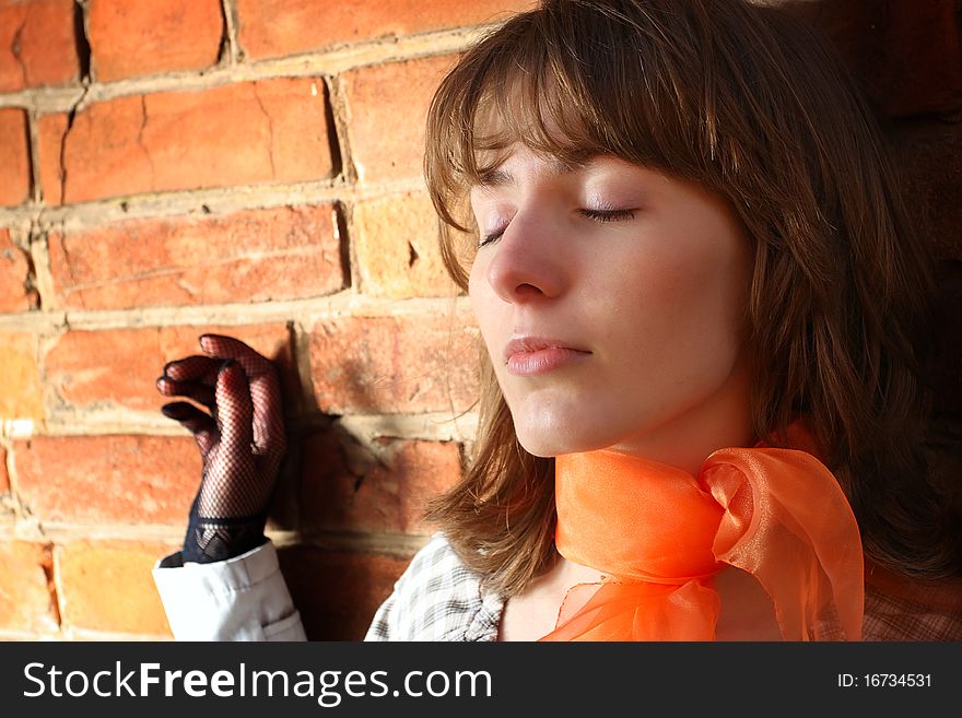 Womanish portrait on a background a brick wall. Womanish portrait on a background a brick wall