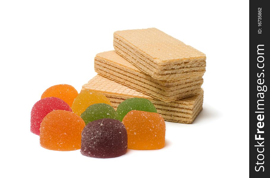 Multi-colored fruit candy and wafers on a white background. Multi-colored fruit candy and wafers on a white background.