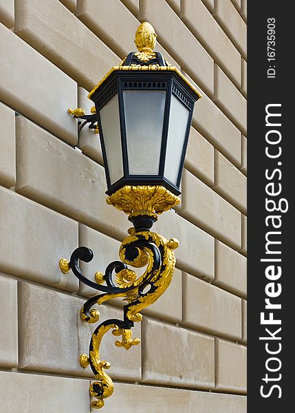 Classic street lantern with gold details on brick wall. Classic street lantern with gold details on brick wall