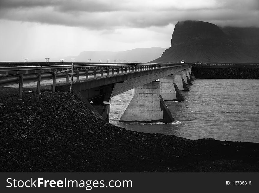 Long bridge over glacier river in Southern Iceland under Vatnajokull glacier.