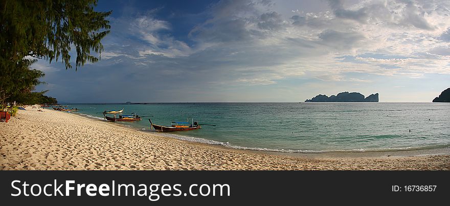 Panoramic view of tropical beach in Koh Phi Phi island with typical Long Tail Boats. Andaman Sea, Thailand. Panoramic view of tropical beach in Koh Phi Phi island with typical Long Tail Boats. Andaman Sea, Thailand