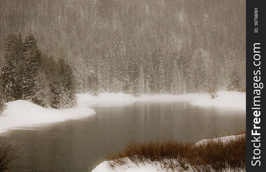 The Snake river winds it's way through Teton National Park in winter and red twig dogwood pokes through the snow. The Snake river winds it's way through Teton National Park in winter and red twig dogwood pokes through the snow.