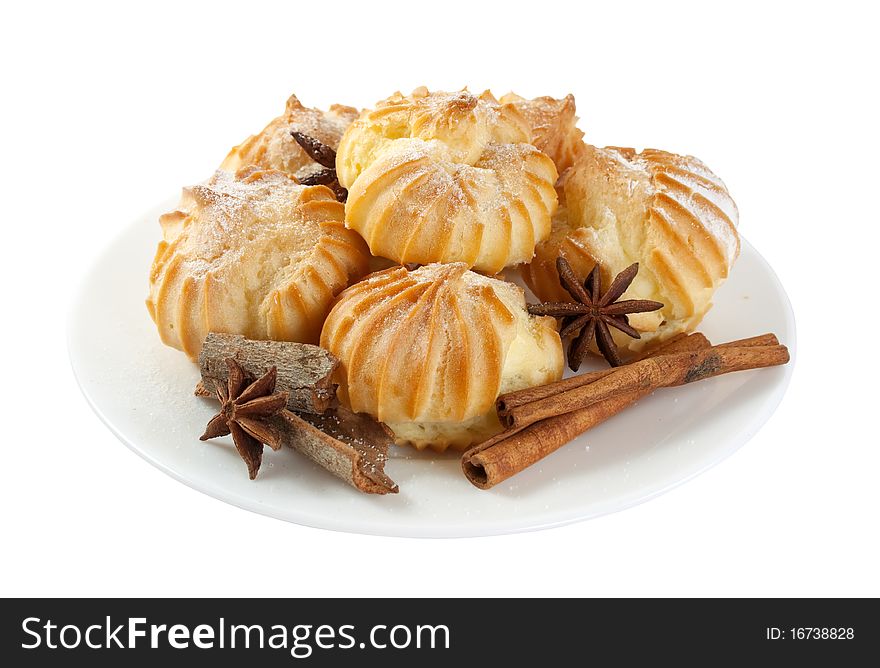 Eclairs and cinnamon on a plate, isolated on a white background