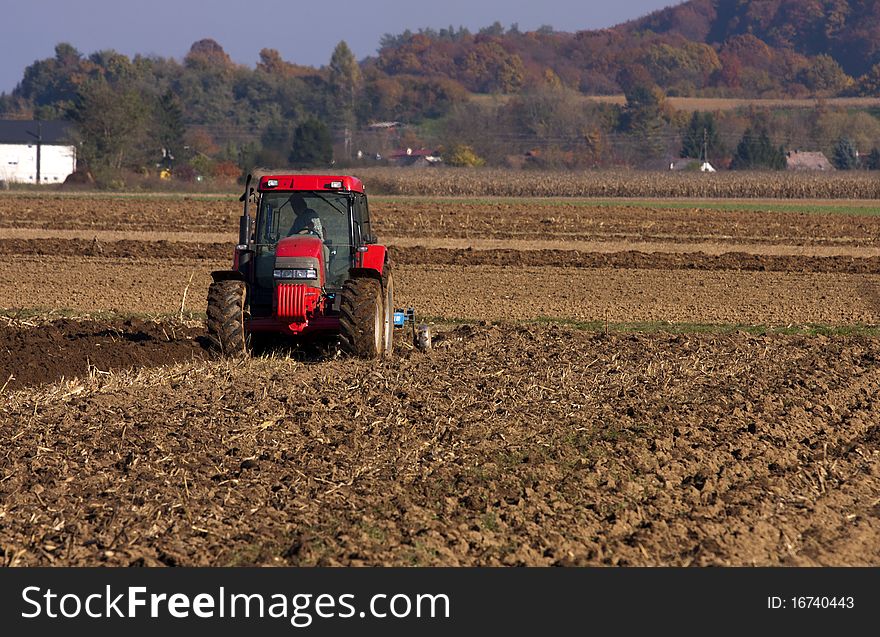 Framer ploughing with the tractor on the autumn fields.