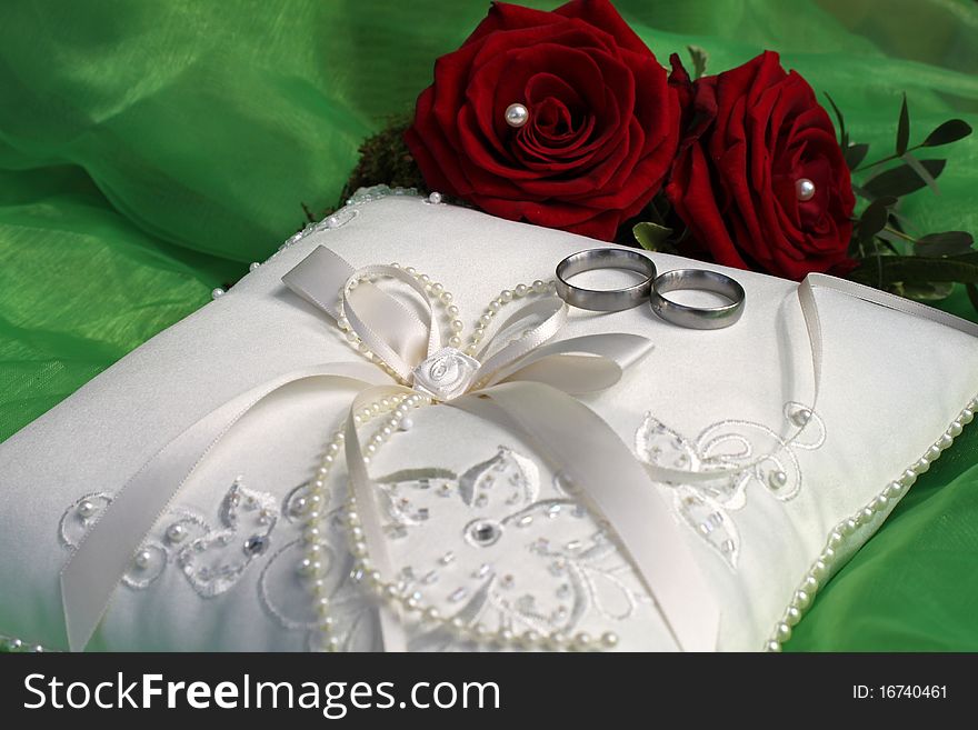 White ring pillow with red roses