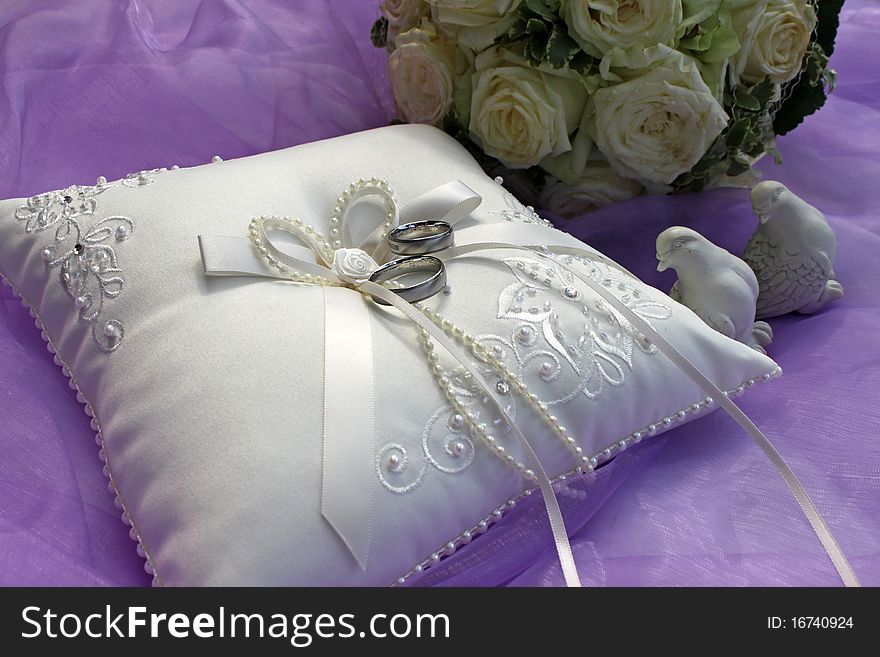White ring pillow with white roses