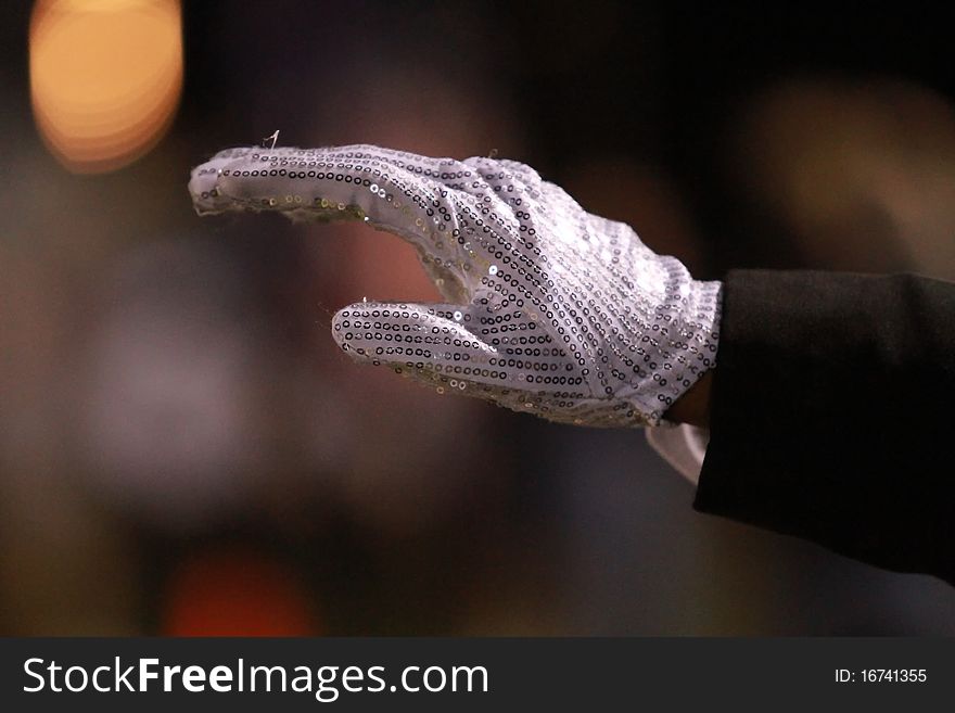 Photo of a hand wearing a sequin white glove. Photo of a hand wearing a sequin white glove