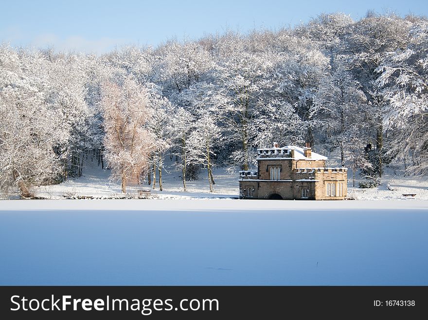A view over a frozen lake to a pumphouse, with snow covered trees in the background. A view over a frozen lake to a pumphouse, with snow covered trees in the background