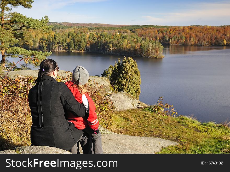 Mother and daughter admire a beautiful autumn's landscape. Mother and daughter admire a beautiful autumn's landscape