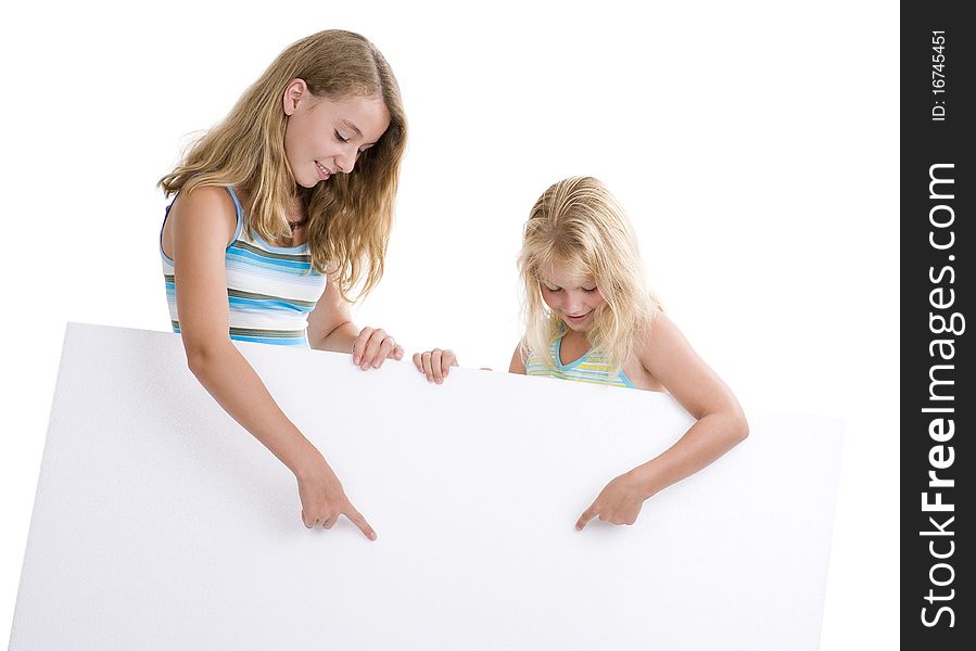 Two blond girls holding a blank display board, isolated on white background. Two blond girls holding a blank display board, isolated on white background