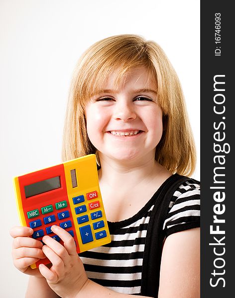 A vertical image of a young girl playing with a calculator. A vertical image of a young girl playing with a calculator