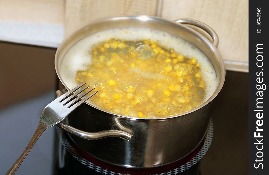 Boiling yellow corn in kitchen pot on stove. Boiling yellow corn in kitchen pot on stove